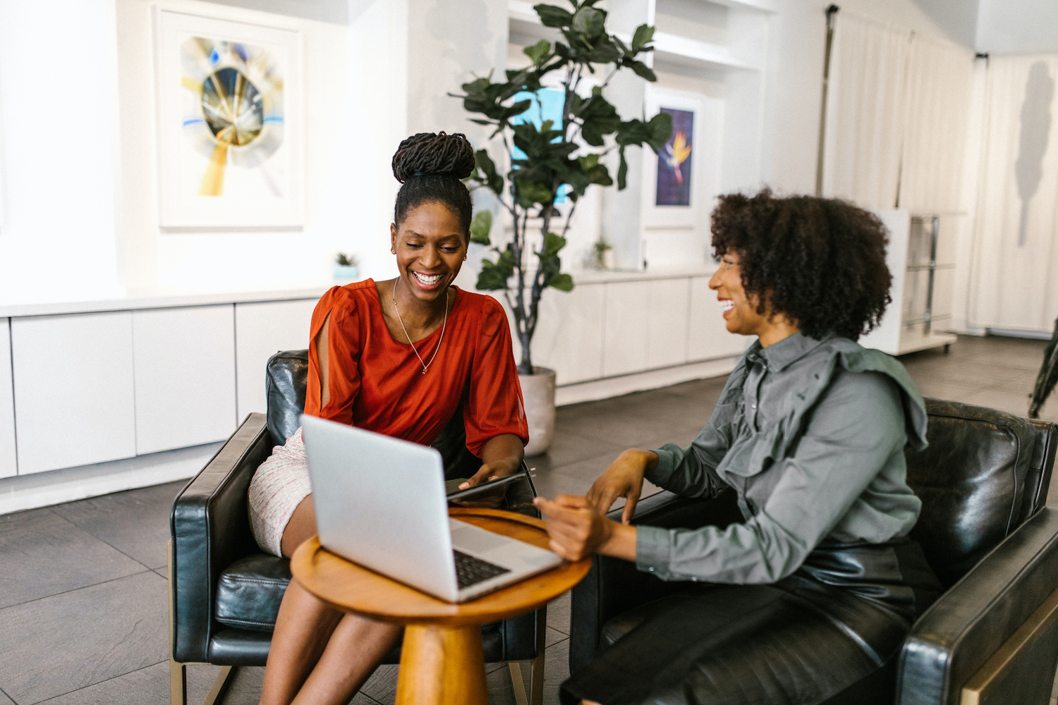 Two women enjoying work together in a high-trust workplace.